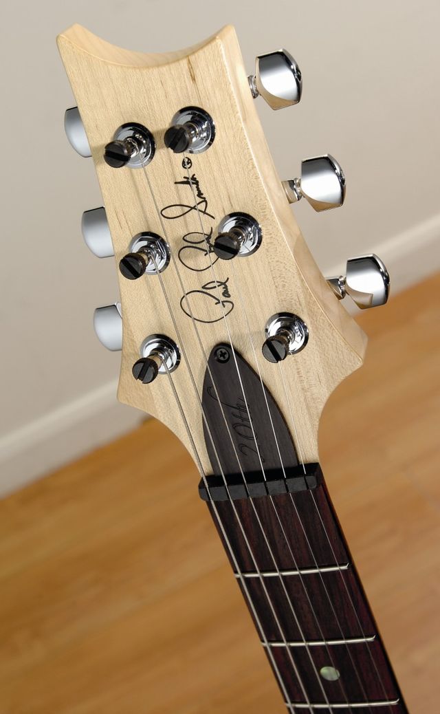The maple headstock creates a contrast with the guitar's rosewood fingerboard